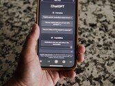 Een hand die een smartphone vasthoudt waarop de ChatGPT-interface is geopend