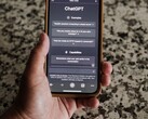 Een hand die een smartphone vasthoudt waarop de ChatGPT-interface is geopend