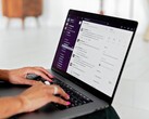 Handen die typen op een laptop met een geopende chatapplicatie