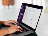 Handen die typen op een laptop met een geopende chatapplicatie