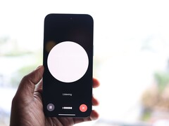 Een hand die een smartphone vasthoudt met een interface voor een spraakassistent op het scherm