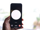 Een hand die een smartphone vasthoudt met een interface voor een spraakassistent op het scherm