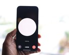 Een hand die een smartphone vasthoudt met een interface voor een spraakassistent op het scherm