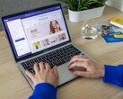Handen die op een laptop typen, met daarop een online winkel te zien.