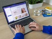 Handen die op een laptop typen, met daarop een online winkel te zien.