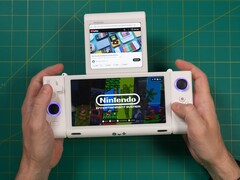 Russ van Retro Game Corps houdt de OneXSugar Sugar 1 handheld spelconsole met twee schermen vast, met een Nintendo-game op het hoofdscherm en een YouTube-video op het secundaire scherm. (Afbeelding Bron: Retro Game Corps op YouTube)