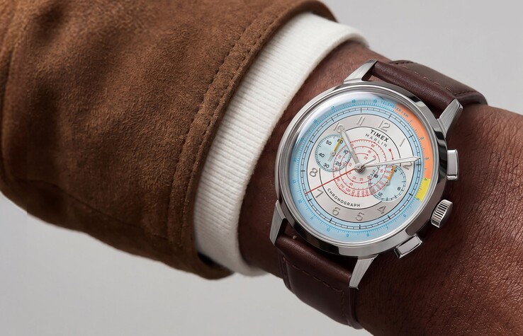 Een Timex Marlin Neo Classic Chronograph met een kleurrijke zilveren wijzerplaat en een bruine leren band, gedragen om de pols.