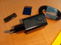 De oplader en kabel, een SD-kaart en USB-stick voor de schaal (Afbeelding bron: Sergey Tarasov - Notebookcheck)