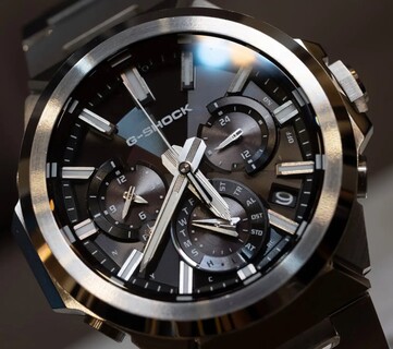 Close-up van de Casio G-Shock GST-W1000D-1A met zwarte wijzerplaat, waarop de drie subwijzerplaten, de lichtgevende uurmarkeringen, de gefacetteerde wijzers en de roestvrijstalen lunette met verschillende afwerkingen te zien zijn.