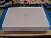 MacBook Neo detailhandeldoos op een werkbank voor de afbraak voor de SSD-upgrade