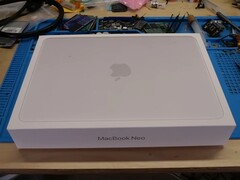 MacBook Neo detailhandeldoos op een werkbank voor de afbraak voor de SSD-upgrade