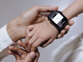 De hand van een volwassene die een smartwatch om de pols van een kind omdoet