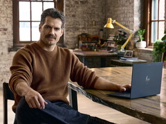 Henry Cavill zit aan een bureau, met een Googlebook binnen handbereik