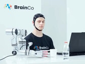 Een gebruiker van de technologie voor gedachtenbesturing van BrainCo die op robotachtige wijze een appel vastpakt door middel van gedachten alleen.