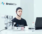 Een gebruiker van de technologie voor gedachtenbesturing van BrainCo die op robotachtige wijze een appel vastpakt door middel van gedachten alleen.