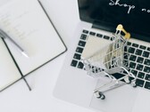 Miniatuurwinkelwagentje op het toetsenbord van een laptop, met ‘Nu winkelen’ op het scherm