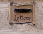Een stenen brievenbus met het woord „Letters“ in een muur uitgehouwen