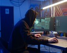 Generieke hacker op een werkstation met twee monitoren die een aanval op de toeleveringsketen uitvoert.