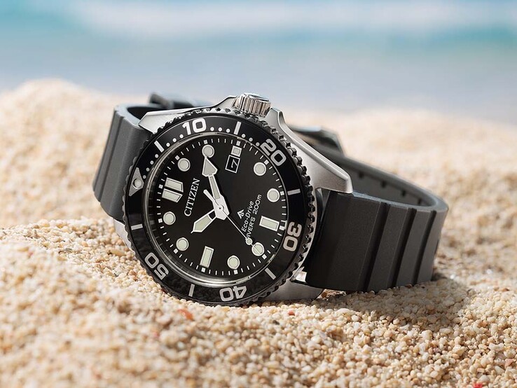 Citizen Promaster Marine BN0266-07E met een zwarte wijzerplaat, zwarte lunette en zwarte band, liggend op zand.