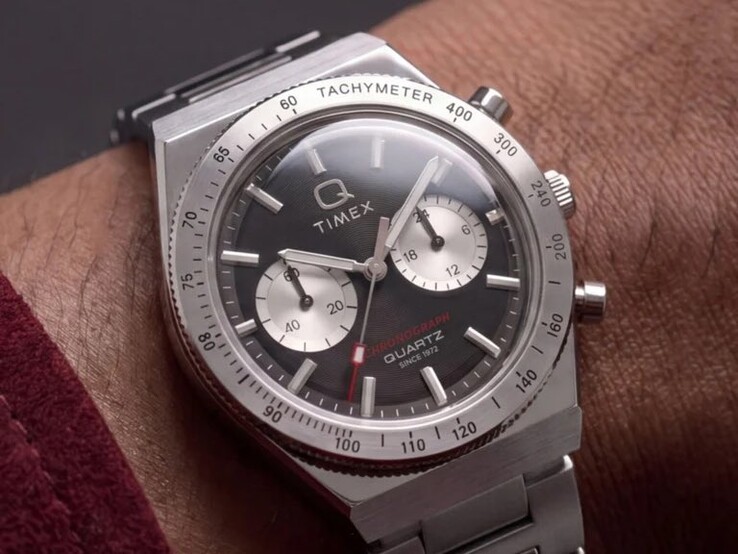 De Timex Q Timex Continental Chronograph TW2Y93200 om de pols, met een zwarte radiale wijzerplaat in CD-stijl, twee zilveren subwijzerplaten, een tachymeterring, lichtgevende markeringen en een geïntegreerde roestvrijstalen armband.