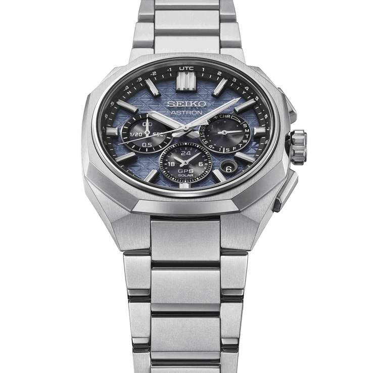 Schuin vooraanzicht van de Seiko Astron HAB001 met de facetgeslepen titanium lunette, de geïntegreerde armband en de blauwe wijzerplaat met structuur.