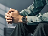 Een Citizen Eco-Drive One AR5065-54W om de pols, met een bosgroene en zwarte wijzerplaat, roségouden accenten en een ultradunne, zwart gecoate armband.