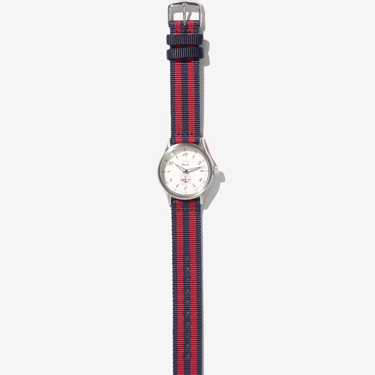 Noah x Timex MK1 Anchor-horloge met een zilverkleurige kast van 36 mm, een crèmekleurige wijzerplaat, een ankerafbeelding en een stoffen band met marineblauwe en rode strepen.