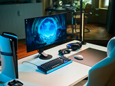 Een strakke gamingopstelling in de studio met de Sony Inzone M10S II-monitor op een wit bureau, naast een verticaal geplaatste PlayStation 5 Pro-console, een mechanisch toetsenbord, een draadloze muis en een headset met subtiele blauwe verlichting.
