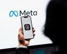 Een hand houdt een smartphone voor een groot Meta-logo