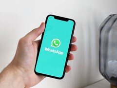 Hand die een smartphone vasthoudt met de WhatsApp-app geopend