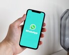 Hand die een smartphone vasthoudt met de WhatsApp-app geopend