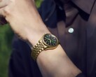Het Seiko Presage Classic x Tradman’s Bonsai-horloge, gedragen om de pols, met een goudkleurige kast en armband en een donkergroene wijzerplaat.