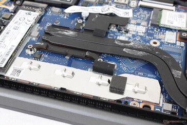 Let op de aluminium plaat die de gesoldeerde RAM modules beschermt en de lege GPU en VRAM slots onder de heat pipes voor de optionele GeForce MX450 SKU's