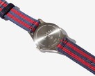 Achterkant van het Noah x Timex MK1 Anchor-horloge, met de gegraveerde roestvrijstalen achterkant en de marineblauw-rode stoffen band.