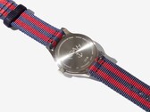 Achterkant van het Noah x Timex MK1 Anchor-horloge, met de gegraveerde roestvrijstalen achterkant en de marineblauw-rode stoffen band.