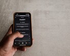 Hand die een smartphone vasthoudt waarop de ChatGPT-interface te zien is, boven een grijs stenen oppervlak