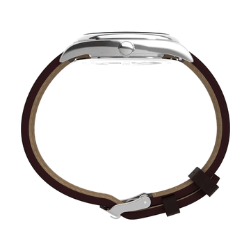Zijaanzicht van de Timex Legacy Day and Date, met de gepolijste roestvrijstalen kast, geribbelde kroon, gebogen bandaanzetten en bruine leren band tegen een witte achtergrond.