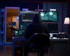 Een onderzoeker met capuchon werkt op meerdere schermen in een verduisterde opstelling. Generieke hacker afgebeeld.