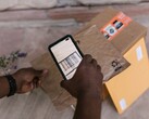 Een hand houdt een smartphone boven een pakket en scant de barcode ervan.