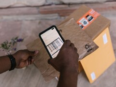 Een hand houdt een smartphone boven een pakket en scant de barcode ervan.