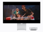 De afbeelding toont de nieuwe M6 Mac mini naast een Studio Display. Er wordt een soort film afgespeeld. 
