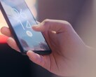 Een hand houdt een smartphone vast en ontgrendelt deze met behulp van de vingerafdruksensor op het vergrendelingsscherm.
