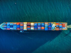 Een luchtfoto van een containerschip (bron: Venti Views via Unsplash; bijgesneden)