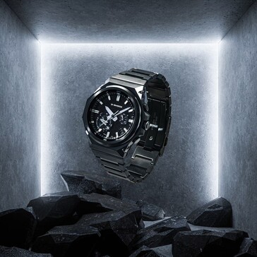 G-Shock GST-B1000BD-1A hangend boven donkere rotsen in een betonnen displayruimte, waarbij de zwarte roestvrijstalen constructie goed tot zijn recht komt.
