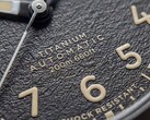 Close-up van de gestructureerde zwarte wijzerplaat van de Timex Expedition Field Post Titanium met Arabische cijfers, lichtgevende wijzers en indexen, en een datumvenster.