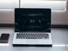 Plaats de laptop en de smartphone naast elkaar op een bureau bij daglicht