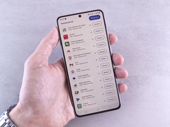 Een hand houdt een smartphone vast waarop een lijst met updates op het scherm te zien is.