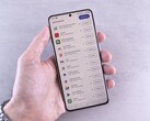 Een hand houdt een smartphone vast waarop een lijst met updates op het scherm te zien is.