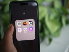 Hand die een smartphone vasthoudt met een map vol AI-apps op het scherm