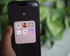 Hand die een smartphone vasthoudt met een map vol AI-apps op het scherm